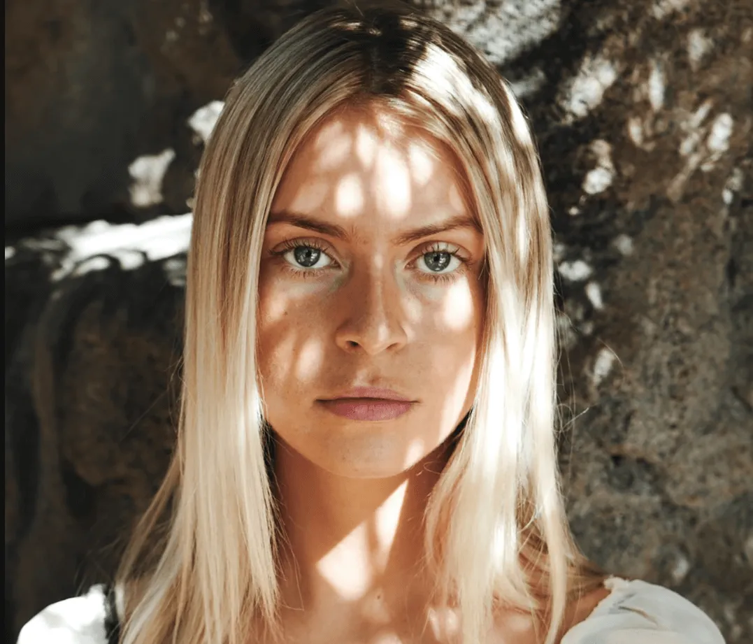 Woman with long blonde hair in dappled sunlight