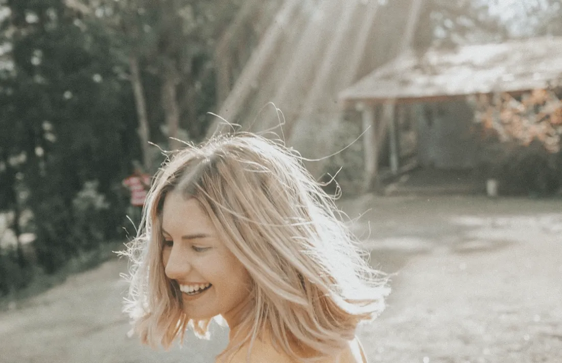 Woman with shoulder-length light hair in sunlight